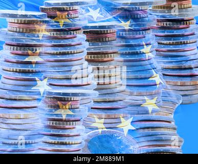 Primo piano di un'esposizione multipla di alcuni mucchi di monete in euro e di una bandiera dell'Unione europea Foto Stock