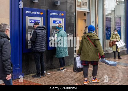 Persone che utilizzano ATM TSB permanenti a Patrick Street, Cork, Irlanda. Foto Stock