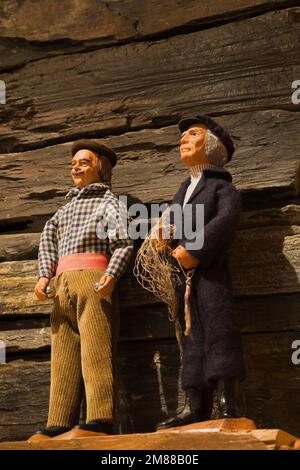 Primo piano di bambole sul camino mantleshelf in camera familiare nel seminterrato all'interno artigianale in legno di abete scandinavo casa. Foto Stock