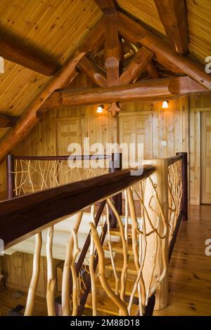 Ringhiere in cedro e pavimenti in legno di pino rosso al piano superiore all'interno di una casa in legno in stile scandinavo. Foto Stock