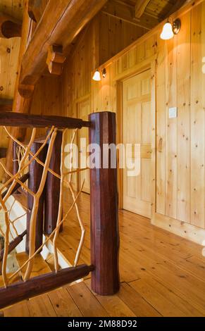 Ringhiere in cedro e pavimenti in legno di pino rosso al piano superiore all'interno di una casa in legno in stile scandinavo. Foto Stock