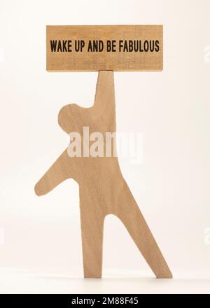 Svegliatevi e siate testo favoloso. È scritto su una superficie di legno. Lo sfondo è bianco Foto Stock