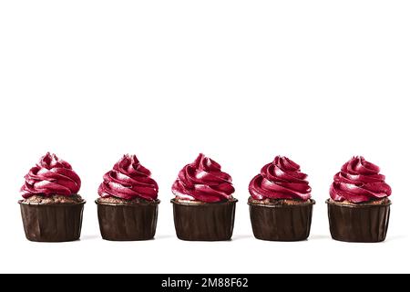 Cinque deliziosi cupcake al cioccolato con glassa su sfondo bianco isolato. Tonalità magenta trendy dell'anno 2023. Mockup per il tuo design. Primo piano. Posiziona per testo. Foto Stock