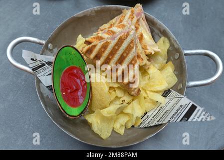 Toast al prosciutto e al formaggio con patatine fritte e ketchup serviti in una ciotola di metallo, Baviera, Germania Foto Stock