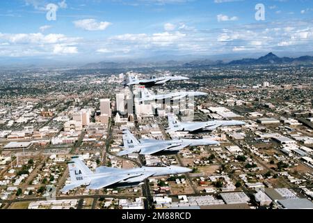 Air to Air Vista laterale destra di una formazione di cinque F-15 Eagle Fighters assegnati a e guidato dalla nave bandiera del 405th Tactical Training Wing (TTW) che sorvola il centro di Phoenix, Arizona. Davanti a dietro l'aeromobile sono assegnati a 555th, 550th TFTS (Tactical Fighter Training Squadron), 405th TTW, 426th e 461st TFTS, Luke AFB, Arizona. Data esatta dell'acquisizione sconosciuta. Paese: Sconosciuto Foto Stock