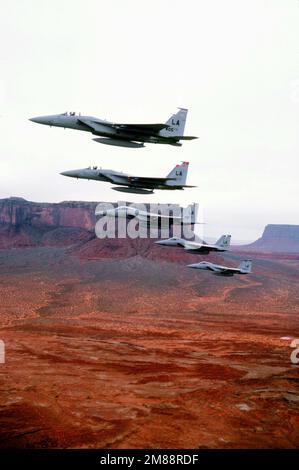 Air to Air vista laterale sinistra di, un echelon destra, formazione di cinque F-15 Eagle combattenti assegnati e guidato dalla nave bandiera del 405th Tactical Training Wing (TTW) volare sopra Monument Valley, Arizona. Da anteriore a posteriore gli aeromobili sono assegnati a 405th TTW, 426th e 461st TFTS (Tactical Fighter Training Squadron), TFTS 550th, 555th TFTS, Luke AFB, Arizona. Data esatta dell'acquisizione sconosciuta. Paese: Sconosciuto Foto Stock