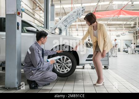 Riparazione di meccanici del personale con il cliente Foto Stock