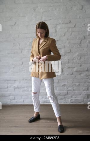 Studio ritratto di giovane modello femminile in blazer beige sartoriale Foto Stock