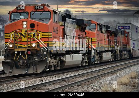 Naperville, Illinois, Stati Uniti. Tre locomotive Burlington Northern Santa Fe conducono un treno merci da Chicago mentre viaggiano attraverso i sobborghi della città. Foto Stock