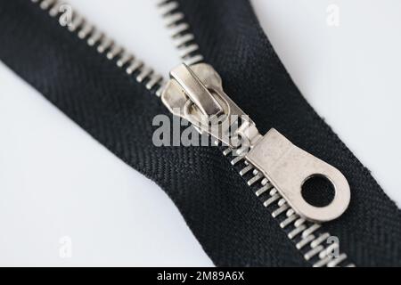 Zip metallica isolata su sfondo bianco. Foto Stock