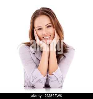 Grazioso e piacevole. Donna vestita casualmente seduta e guardare rilassata - isolato su bianco. Foto Stock