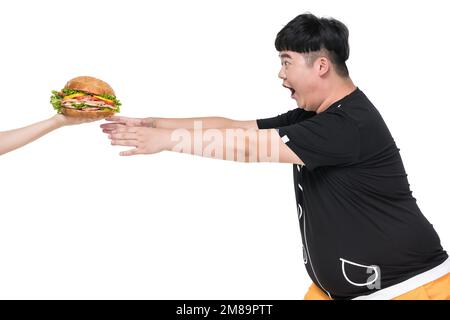 Il giovane obeso cadde sul cibo Foto Stock