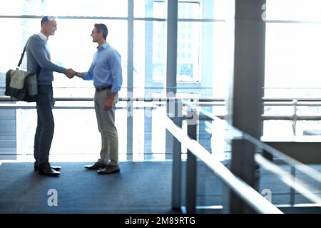 Uomini d'affari, accordi di stretta di mano e partnership nella hall dell'hotel, nell'ufficio moderno o nella lounge dell'aeroporto durante una riunione del team CRM. Persone aziendali, dipendenti e. Foto Stock