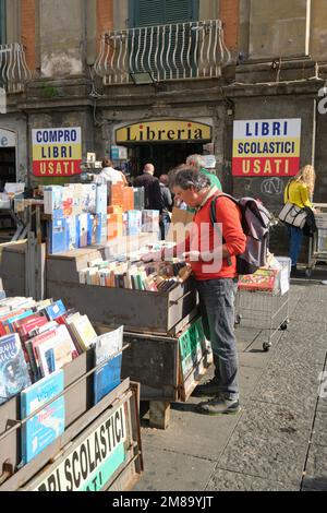 Un uomo acquirente guarda attraverso i bidoni usati in uno dei negozi di Dante piazza. A Napoli, Napoli, Italia, Europa. Foto Stock
