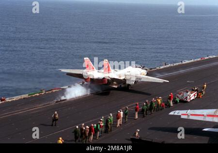 Gli equipaggi della piattaforma di volo guardano come un aereo Fighter Squadron 31 (VF-31) F-14A Tomcat accelera verso la fine del ponte della portaerei USS FORRESTAL (CV-59). Paese: Sconosciuto Foto Stock