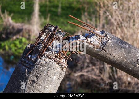 Pilastro in calcestruzzo rotto con rinforzo in acciaio arrugginito Foto Stock