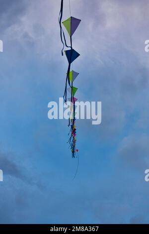 Uno scatto verticale di una serie di aquiloni colorati visti galleggiare nel cielo Foto Stock