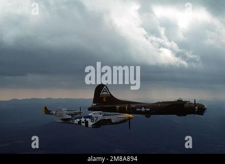 Una vista sul lato destro dell'aereo restaurato della Fortezza volante B-17G 'Shoo Shoo Shoo Baby' in volo, scortato da due aerei da combattimento P-51 Mustang restaurati della stessa epoca. Paese: Sconosciuto Foto Stock