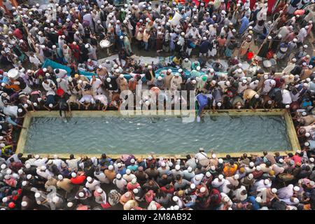 Dhaka, Dhaka, Bangladesh. 13th Jan, 2023. I devoti musulmani si riuniscono per utilizzare l'acqua fornita durante la Bishwa Ijtema (Congregazione Globale) mentre i musulmani si riuniscono lungo le rive del fiume Turag, alla periferia di Dhaka. È la seconda congregazione più grande della comunità musulmana dopo il pellegrinaggio alla Mecca per gli Hajj. A causa della non politica, attira persone di ogni persuasione ed è frequentato da devoti di 150 paesi. Culmina nell'Akheri Munajat o nella supplica conclusiva (preghiera finale) in cui milioni di devoti alzano le mani davanti ad Allah e pregano per la WO Foto Stock