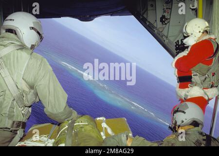 Babbo Natale (SSGT Ernest A. Allen) e un altro aviatore guardare giù dalla baia di carico del loro C-130 Hercules velivolo, che sta trasportando i regali di Natale donati dal paracadute sulle isole locali. I regali sono stati raccolti da volontari dello Squadrone di polizia di sicurezza del 43rd, dello Squadrone di supporto di Airlift militare del 605th e dello Squadrone di manutenzione delle Munizioni del 43rd. Stato: FS Micronesia (FM) Nazione: Stati Uniti d'America (USA) Foto Stock