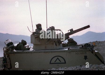 Indossando maschere di protezione biologica-chimica, tre soldati della Divisione di Fanteria 24th (meccanizzata) uomo un M-163 Vulcan auto-propulsivo anti-aereo pistola durante un esercizio presso il National Training Center. L'M-163 è costituito da un cannone Vulcan M-168 20mm con controllo antincendio radar montato su una portante del personale blindato M-113 modificata. Base: Fort Irwin Stato: California (CA) Nazione: Stati Uniti d'America (USA) Foto Stock