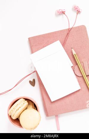 Oggetti femminili in oro e rosa, tra cui articoli da cancelleria, auricolari, cuore e macaron Foto Stock