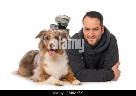 Uomo con il suo cane pastore australiano su sfondo bianco Foto Stock