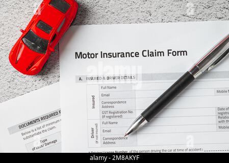 Modulo di richiesta di assicurazione auto o motore con penna a sfera e modello di auto Foto Stock