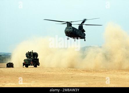 Un elicottero CH-47 Chinook solleva una nuvola di polvere mentre si avvicina per raccogliere un pezzo di attrezzatura sul campo durante l'esercizio Team Spirit '89. Soggetto operativo/Serie: TEAM SPIRIT '89 Paese: Corea del Sud Foto Stock