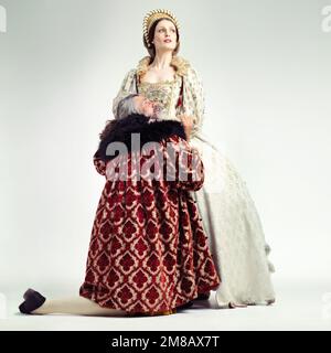 Amore, confessione e un re che pregava una regina di perdono in studio su uno sfondo grigio come un regnante. Coppia, corona o medievale con un uomo Foto Stock