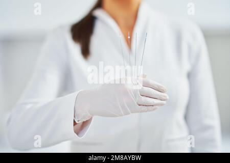 Immagine di una donna che indossa guanti con fili cosmetici Foto Stock