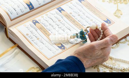 Il Ramadan 2023 è tra marzo 23 e aprile 21. Vecchia donna che legge il Santo Corano nel Ramadan. Benvenuti Ramadan. 13 gennaio 2023 - Istanbul, Turchia. Foto Stock