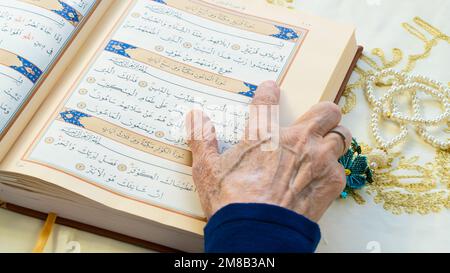 Il Ramadan 2023 è tra marzo 23 e aprile 21. Vecchia donna che legge il Santo Corano nel Ramadan. Benvenuti Ramadan. 13 gennaio 2023 - Istanbul, Turchia. Foto Stock
