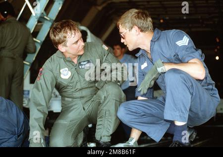 Ransom, 22nd Military Airlift Squadron loadmaster, e SGT Bret Hartman, il suo omologo della Royal Australian Air Force (RAAF), conferiscono nella stiva di un aereo militare Wing C-5A Galaxy 60th durante l'operazione elezione Distretto. Il C-5 sta assumendo un contingente di ingegneri australiani reali che costruiranno strutture per il gruppo di assistenza alla transizione delle Nazioni Unite (UNTAG), forze di mantenimento della pace che monitorano le elezioni del novembre 1989 e l'indipendenza della Namibia. Base: RAAF Richmond Paese: Australia (AUS) Foto Stock