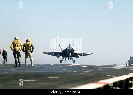 Gli equipenti della piattaforma di volo guardano un aereo F/A-18 Hornet che tocca l'INDIPENDENZA della USS (CV-62) durante le qualifiche del vettore della Reserve Carrier Air Wing 30 (CVWR-30) al largo della costa della California meridionale. Paese: Oceano Pacifico (POC) Foto Stock