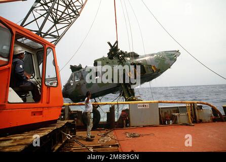 Un lavoratore a bordo della nave di salvataggio giapponese SHIN TATSU MARU segnala all'operatore della gru come un elicottero Jolly Green Giant dell'aeronautica HH-3E è issato dall'oceano a 5,6 miglia al largo della costa di Okinawa, Giappone. Il recupero dell'elicottero, che si è schiantato durante una missione di allenamento notturno e ha affondato in 1.800 piedi d'acqua, è uno sforzo congiunto tra Stati Uniti e Giappone. Paese: Sconosciuto Foto Stock