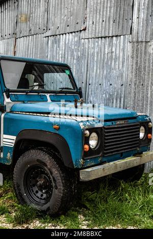 Vecchio classico pick-up Land Rover vicino al capannone di metallo Foto Stock