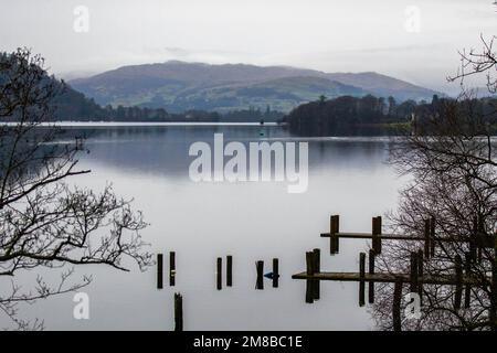 Molo affondato sul lago Windermere circondato da montagne in una giornata nuvolosa Foto Stock