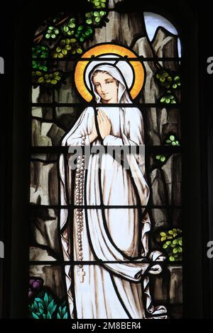 Sainte Bernadette. Baie du XIXème. La chapelle de l'Immaculée Conception. Artiste : Jean-Michel Alberola. Maître verrier : Dominique Duchemin. Cathéd Foto Stock