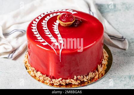 Torta al lampone. Torta di compleanno o festeggiamenti ricoperta di lampone all'esterno e ripiena di frutti di bosco. Design speciale. primo piano Foto Stock