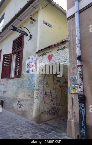 Ingresso alla strada Sforii (strada di corda). La strada più stretta di Brașov Romania, una delle più strette d'Europa. Un cartello con il nome della strada è appeso accanto ad esso Foto Stock