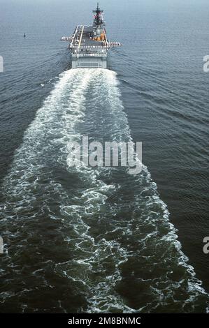 Una vista aerea di poppa degli equipe che presergono le rotaie sulla nave d'assalto anfibio USS WASP (LHD-1) mentre la nave si avvicina alla Stazione Navale di Norfolk per la sua cerimonia di messa in servizio. La prima nave della sua classe, WASP combina capacità di ponte di volo e di pozzo con un centro di informazioni sul combattimento all'avanguardia e diversi sistemi di recente sviluppo. Base: Hampton Roads, Norfolk Stato: Virginia (VA) Nazione: Stati Uniti d'America (USA) Foto Stock