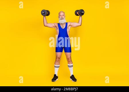 Foto a tutta lunghezza del braccio muscolare di un allenatore sportivo professionista senior sollevamento pesante vestito da barbell usura isolato su sfondo giallo Foto Stock