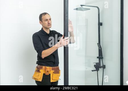 Plumber installazione di una cabina doccia in bagno Foto Stock