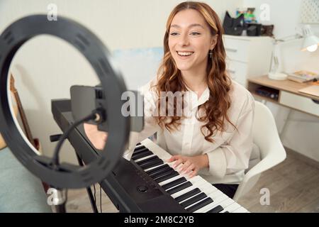 Allegro musicista che si prepara a registrare musica vlog per il pubblico online Foto Stock