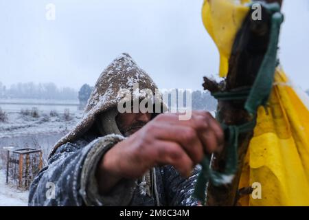 13 gennaio 2023, Srinagar, Jammu e Kashmir, India: Un venditore ha visto chiudere il suo stallo dopo una fresca nevicata nella periferia di Srinagar. Il freddo continuava ad influenzare le alte portate del Kashmir, con la temperatura che scenda al di sotto del punto di congelamento. (Credit Image: © Adel Abbas/ZUMA Press Wire) SOLO PER USO EDITORIALE! Non per USO commerciale! Foto Stock