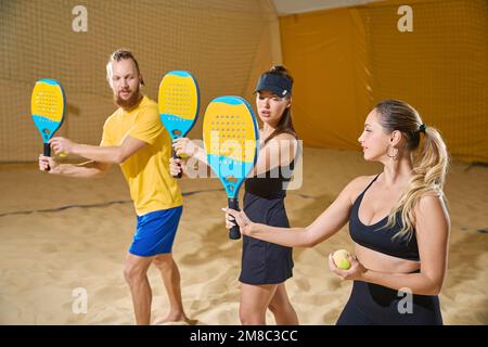 Uomo e tre donne e tenere le racchette nelle loro mani Foto Stock