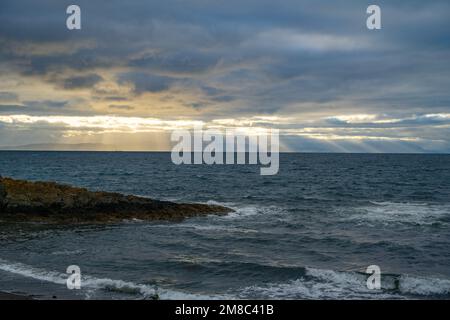 Il sole si irradia da dietro le nuvole sopra l'isola di Arran nel Firth di Clyde, da Dunure Ayrshire Scozia Foto Stock