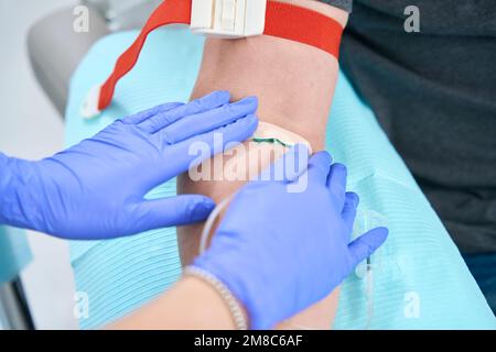 Il paziente fornisce un campione di sangue da una vena Foto Stock