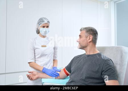 L'uomo effettua un esame del sangue da una vena Foto Stock
